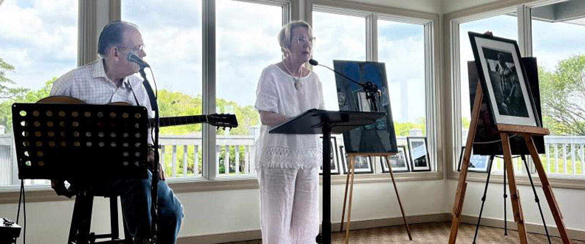 Celebrating the fifth anniversary of the Rehoboth Beach Writers’ Guild Art in the A.M. program are musician Stuart Vining, left, and emcee Lisa Graff. Two of the featured artworks are also visible.